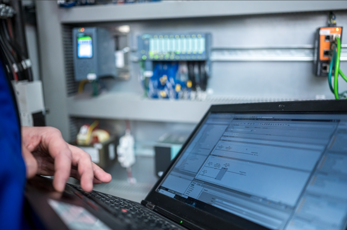 A programmer troubleshooting a PLC in an industrial facility.